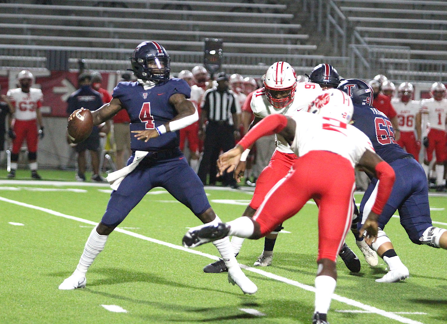 Tompkins senior quarterback Jalen Milroe (4) stands tall in the pocket as Katy junior defensive end Malick Sylla attempts to rush during the Falcons' 24-19 win over Katy on Nov. 5 at Legacy Stadium.